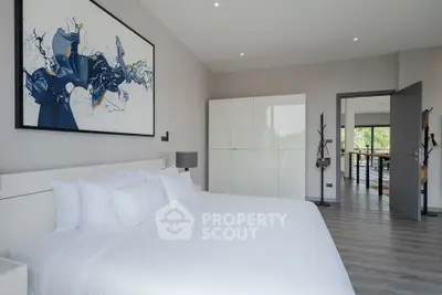 Spacious modern bedroom with elegant decor and large windows offering natural light.