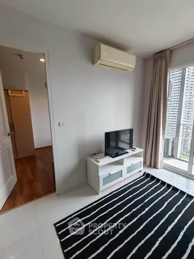 Modern living room with city view, featuring sleek TV stand and air conditioning, perfect for urban living.