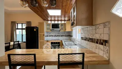 Modern kitchen with wooden ceiling and breakfast bar in stylish home