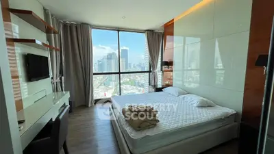 Modern bedroom with city view, featuring sleek furniture and large window.