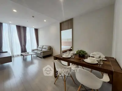 Modern living room with dining area and stylish furniture in open layout apartment.