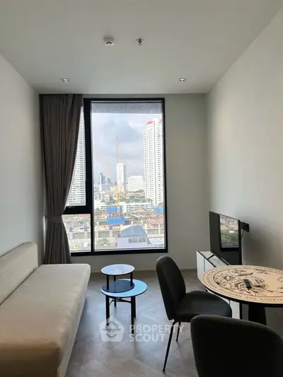 Modern living room with city view, stylish furniture, and large window in urban apartment.