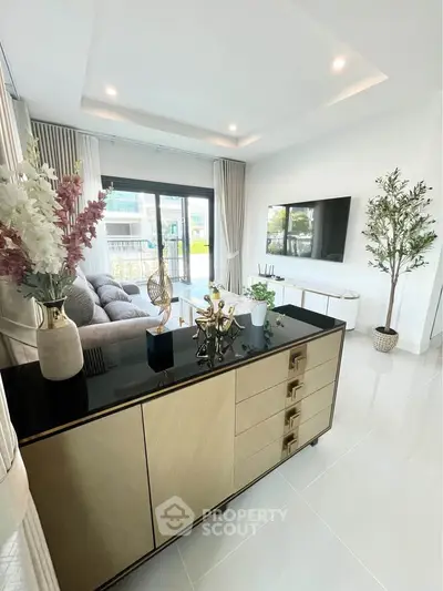 Modern living room with elegant decor and large windows offering natural light.