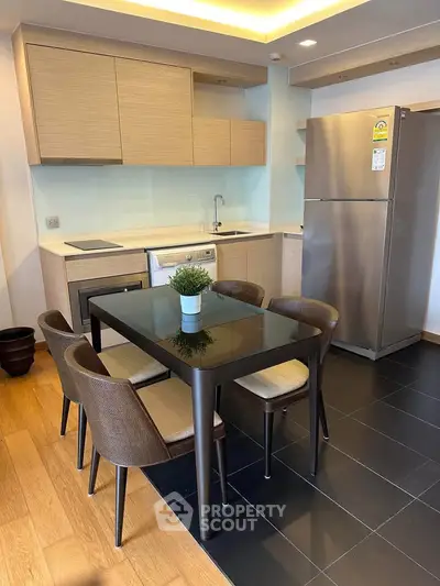 Modern kitchen with sleek dining area and stainless steel appliances in a stylish apartment.