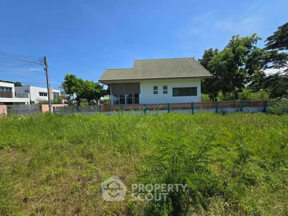 Charming single-story house with spacious yard and lush greenery, perfect for serene living.