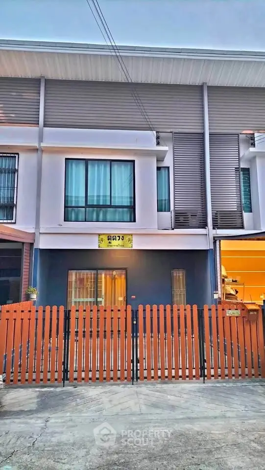 Modern townhouse exterior with wooden fence and large windows