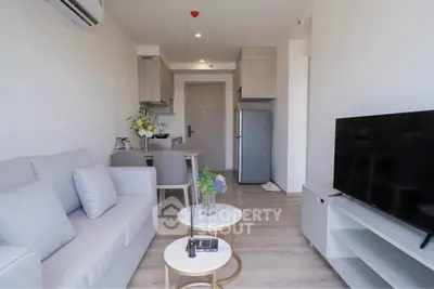 Modern living room with cozy sofa, stylish decor, and open kitchen layout in a contemporary apartment.