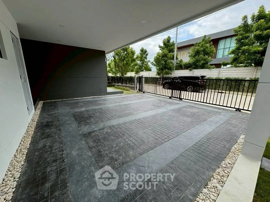 Spacious modern parking area with sleek design and gated entrance in a contemporary property.