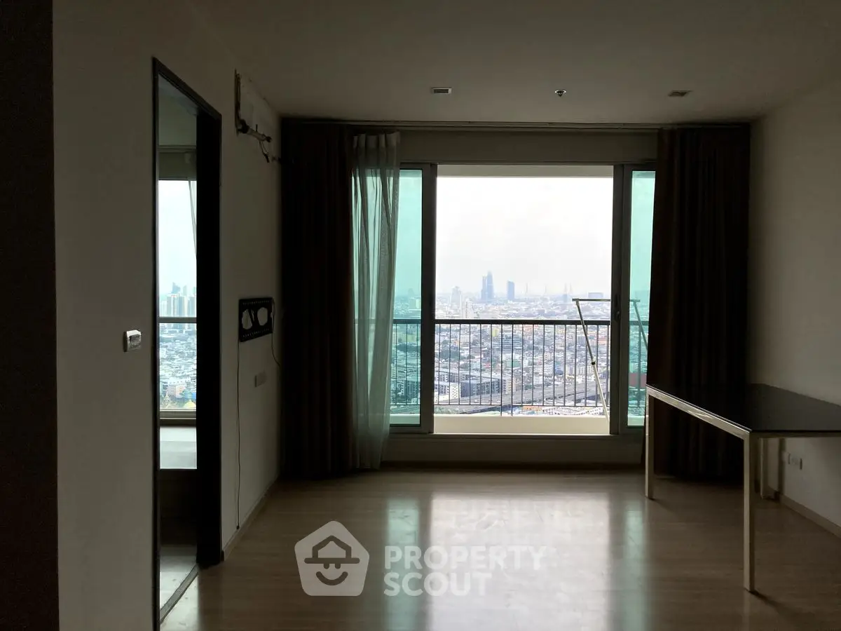 Spacious apartment with stunning city view from large windows and balcony access.