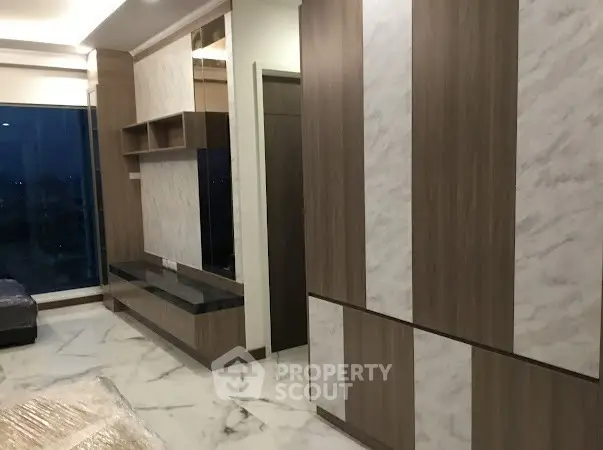 Modern interior with elegant wood paneling and marble flooring, featuring built-in storage and large windows.