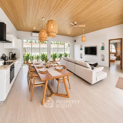 Spacious open-plan living room with modern kitchen and elegant dining area, featuring natural wood accents and ample natural light.
