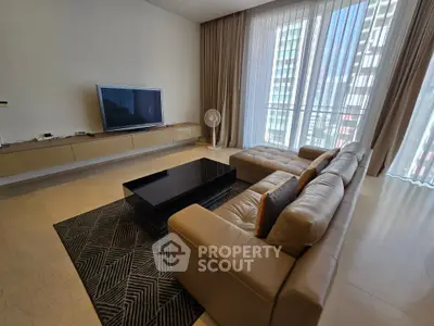 Luxurious living room with modern decor, large TV, and floor-to-ceiling windows offering city views.