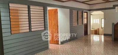 Spacious interior with wooden accents and tiled flooring, featuring a cozy kitchen area.