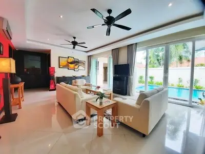 Spacious living room with pool view, modern decor, and large windows for natural light.