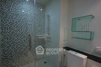 Modern bathroom with glass shower and mosaic tile wall