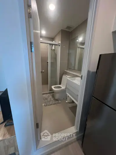 Modern compact bathroom with glass shower and sleek fixtures in a contemporary apartment.