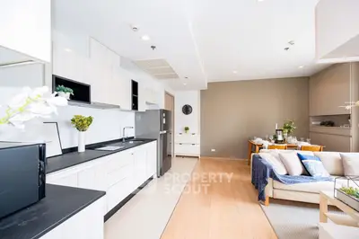 Modern open-layout kitchen and living room with stylish decor and natural light.