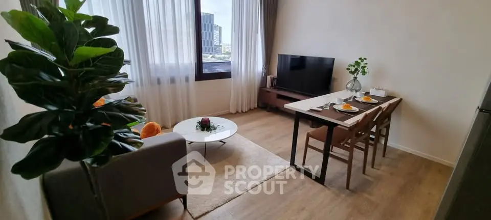 Modern living room with dining area, large window, and stylish decor in urban apartment.