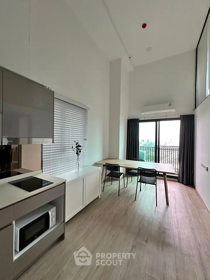 Modern open-plan living area with high ceilings and balcony view