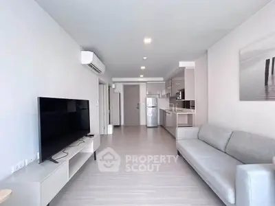 Modern living room with sleek furniture and open kitchen layout in a stylish apartment.