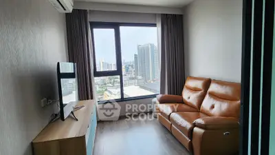 Modern living room with city view, leather sofa, and sleek TV setup.