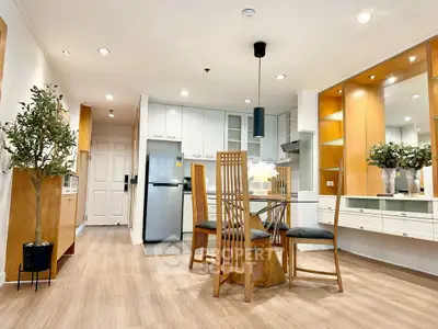 Modern dining area with wooden furniture and sleek kitchen appliances in open layout.