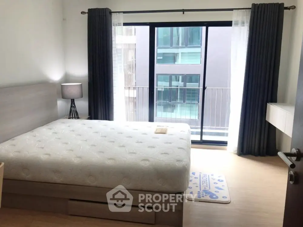Modern bedroom with large window and stylish decor in urban apartment