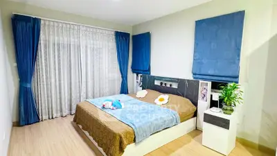 Spacious bedroom with modern decor and large windows for natural light.