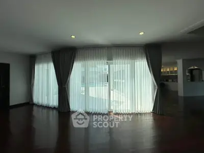 Spacious living room with elegant curtains and pool view, perfect for modern living.