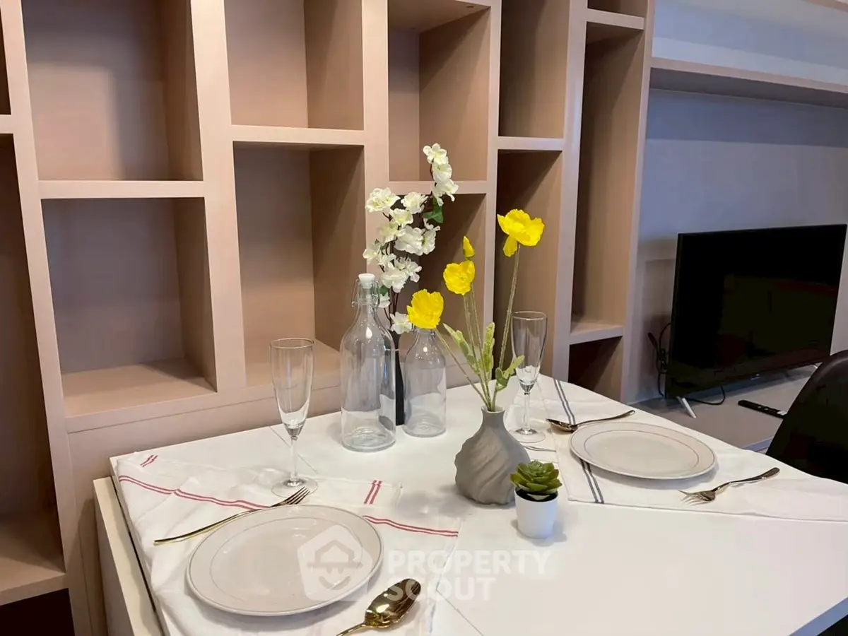 Elegant dining setup with modern shelving and TV in stylish living area