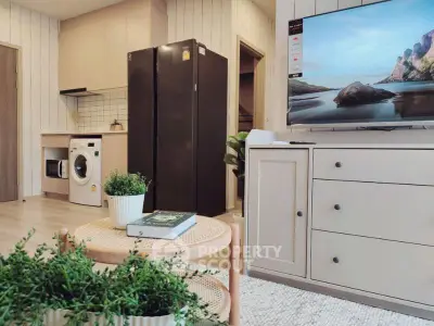 Modern living room with open kitchen, featuring sleek appliances and stylish decor.