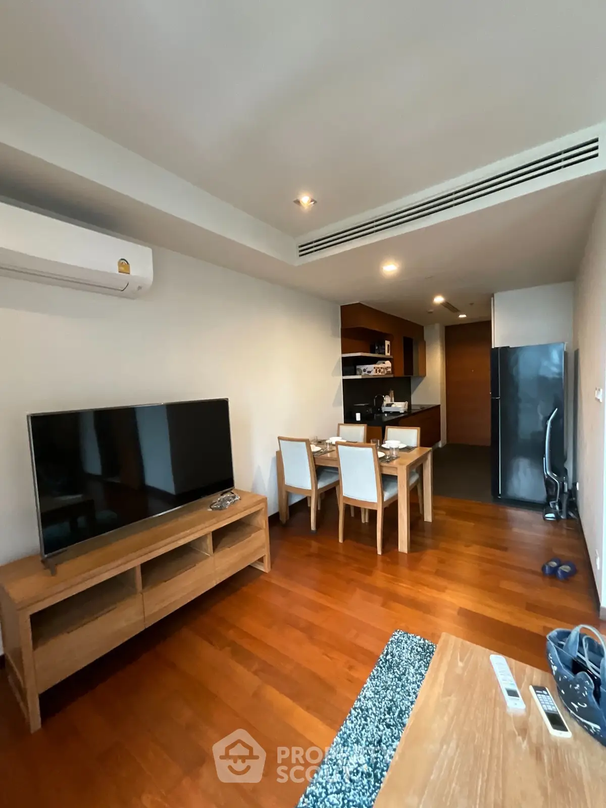 Modern living room with wooden flooring and open kitchen layout