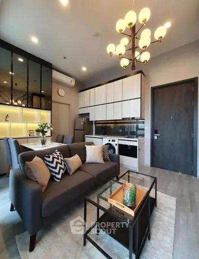 Modern living room with open kitchen, stylish decor, and elegant lighting in a cozy apartment.