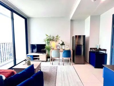 Modern living room with sleek furniture and large windows offering natural light.