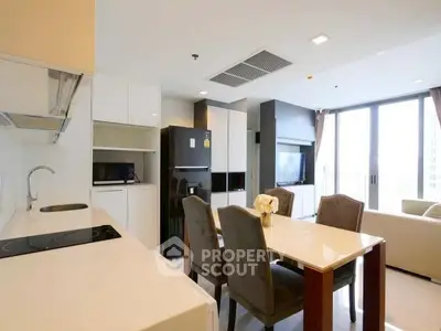 Modern open-layout kitchen and dining area with sleek appliances and elegant decor.
