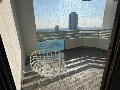 Spacious balcony with modern chair and stunning city view, perfect for relaxation and enjoying the skyline.