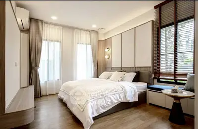 Elegant bedroom with modern decor, large windows, and cozy ambiance in a stylish apartment.