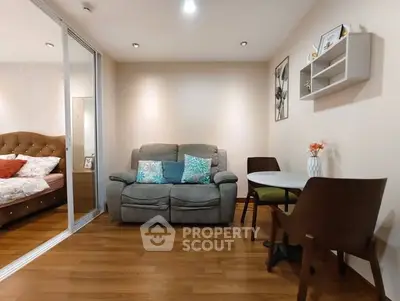 Cozy living room with wooden flooring, plush sofa, and dining area in modern apartment.
