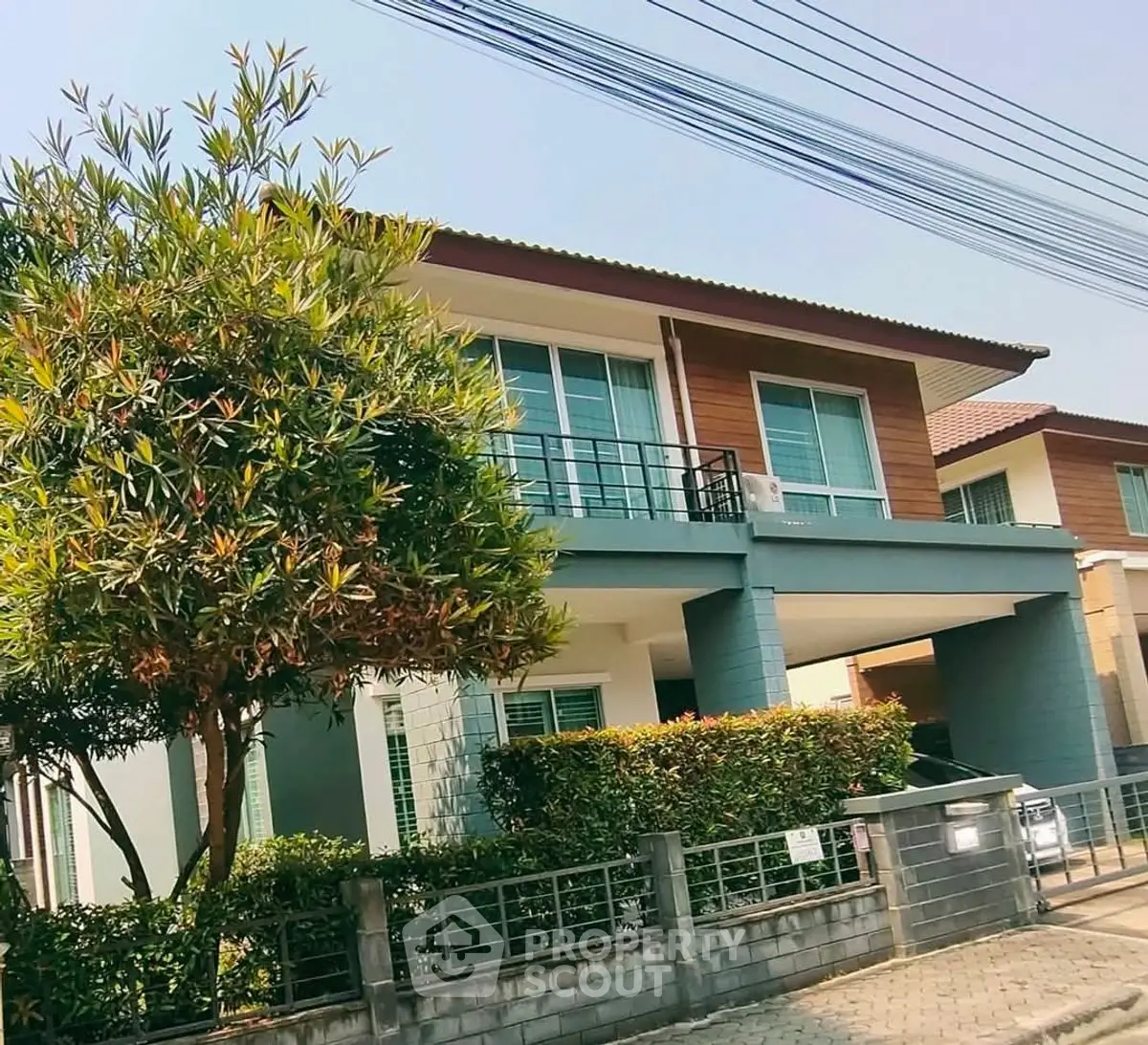 Modern two-story house with lush greenery and spacious driveway in a serene neighborhood.
