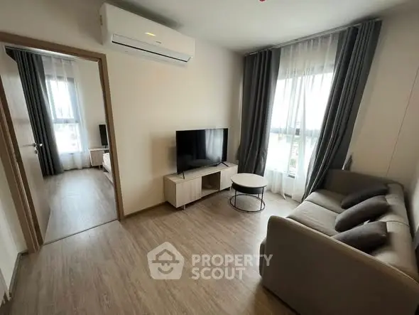 Modern living room with sleek furniture and large windows in a stylish apartment.