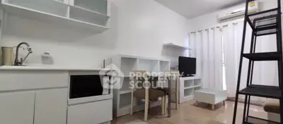 Modern compact living room with kitchen, dining area, and TV setup in a bright, airy space.