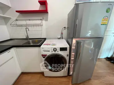 Modern kitchen with washing machine and fridge in compact layout