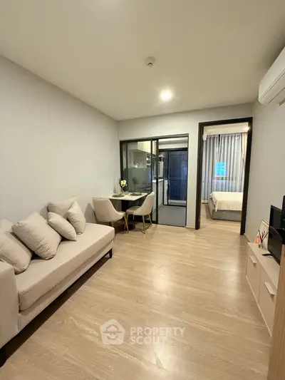 Modern living room with cozy sofa and dining area, leading to a stylish bedroom.