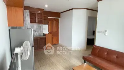 Cozy studio apartment with compact kitchen and modern furnishings, ideal for urban living.