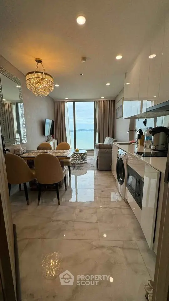 Luxurious open-plan living room with ocean view and elegant chandelier