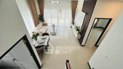 Spacious modern living room with elegant decor and dining area, featuring large windows and stylish furnishings.