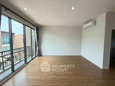 Spacious modern living room with large windows and wooden flooring