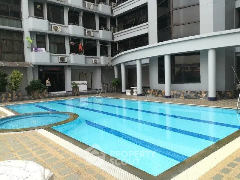 Luxurious apartment complex with a pristine swimming pool and modern architecture.