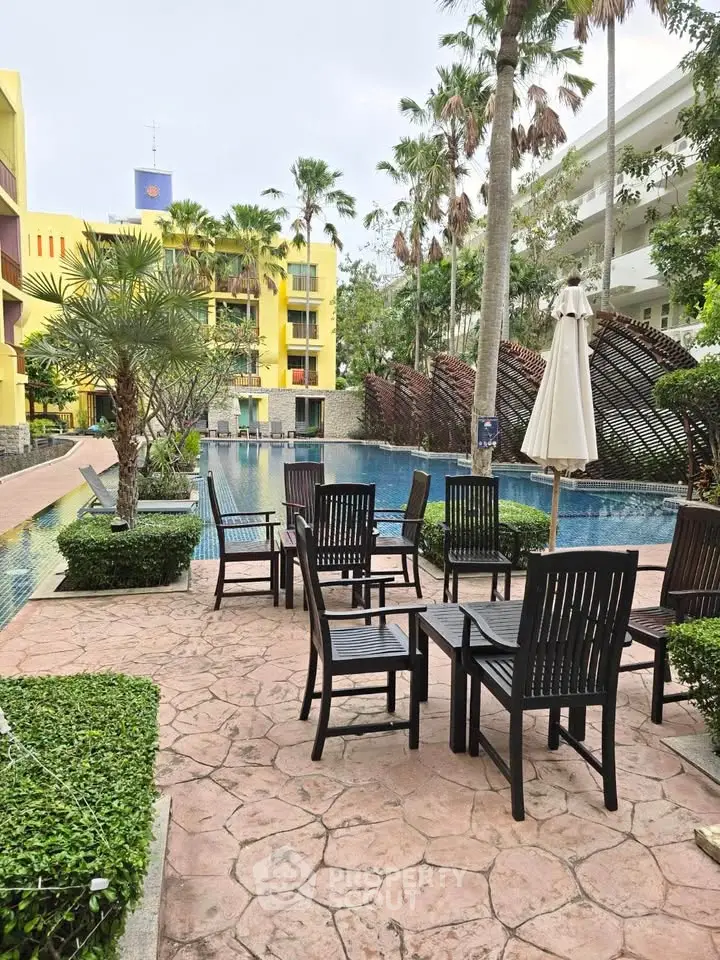 Luxurious poolside area with elegant seating and lush greenery in a modern residential complex.