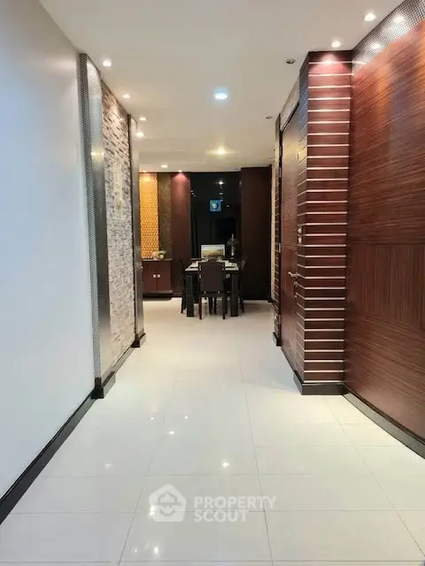 Elegant hallway with modern lighting leading to a stylish dining area in a contemporary home.